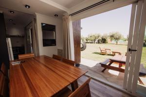 ein Wohnzimmer mit einem Holztisch und einer Glasschiebetür in der Unterkunft Finca La Escondida San Rafael in San Rafael