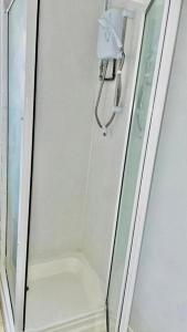 a shower with a glass door next to a shower at Cosy 1 Bed Budget Apartment Near Blackpool City Centre 1 in Blackpool