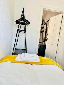 a room with a bed with a yellow blanket and a ladder at Cosy 1 Bed Budget Apartment Near Blackpool City Centre 1 in Blackpool