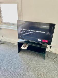 a flat screen tv sitting on top of a tv stand at Cosy 1 Bed Budget Apartment Near Blackpool City Centre 1 in Blackpool