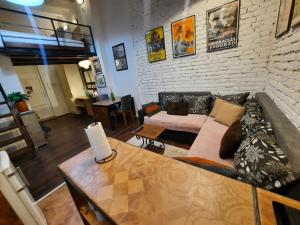 a living room with a couch and a table at Authentic Belgrade Centre - Split level loft with patio in courtyard in Belgrade