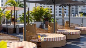 een patio met tafels en parasols op een dak bij Uma House by Yurbban South Beach in Miami Beach