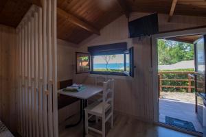 een kleine kamer met een bureau en een raam bij Camping Ria de Arosa 1 in Pobra do Caramiñal