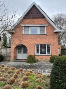 a red brick house with a large window at Grote vakantiewoning nabij Brugge! in Damme