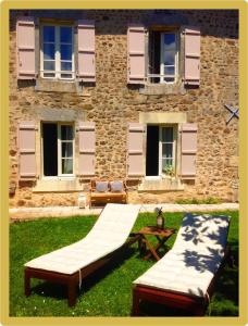 dos camas en el césped frente a un edificio en Cardabelle Holiday Home with private garden en Mazières