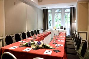 une rangée de tables dans une pièce avec un tissu de table rouge dans l'établissement Carlton Lausanne Boutique Hôtel, à Lausanne