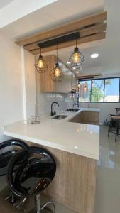 uma cozinha com um balcão branco e uma cadeira preta em Hermoso apartamento céntrico em Santa Cruz de Mompox