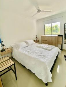 a white bedroom with a large bed and a window at Hermoso apartamento céntrico in Mompos