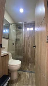 a bathroom with a toilet and a glass shower at Hermoso apartamento céntrico in Mompos