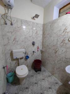 La salle de bains est pourvue de toilettes et d'un lavabo. dans l'établissement OYO Ambika Guest House, à Pushkar