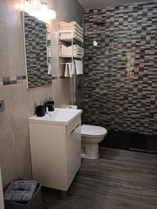 ein Badezimmer mit Toilette, Waschbecken und Dusche in der Unterkunft Bungalow Esperanza in Costa Teguise