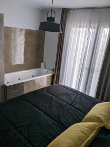 1 dormitorio con cama y ventana con bañera en Finca La Escondida San Rafael en San Rafael