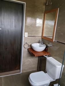 a bathroom with a sink and a toilet and a mirror at Finca La Escondida San Rafael in San Rafael