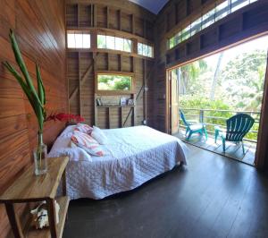 um quarto com uma cama num quarto de madeira em Colinas del Palmar em Bocas del Toro