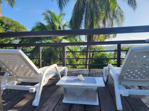 two chairs and a table on a deck at Colinas del Palmar in Bocas del Toro