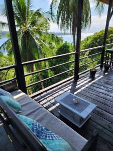 a porch with a couch and a view of the ocean at Colinas del Palmar in Bocas del Toro
