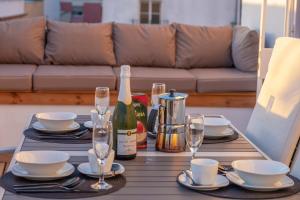 a table with a bottle of wine and glasses at Penthouse with Jacuzzi, and garaje Grupo AC Gestion in Cádiz