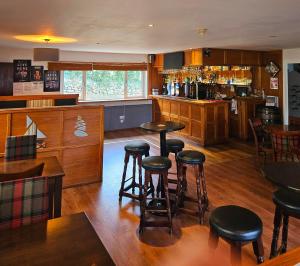 a bar with tables and stools in a restaurant at Park Lodge Hotel in Tobermory