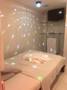 a room with a bed with lights on the wall at Pousada Ybyrápuan in Campina Grande