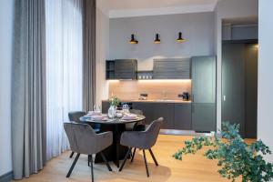 a kitchen and dining room with a table and chairs at Belhome Lutsu Apartment in Old Town in Tartu