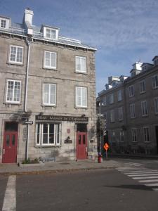 an old building with red doors on a street at Hôtel Manoir de l'Esplanade in Quebec City