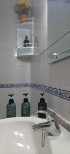 um lavatório de casa de banho com duas garrafas de sabão em SOLEA 17 em Rota