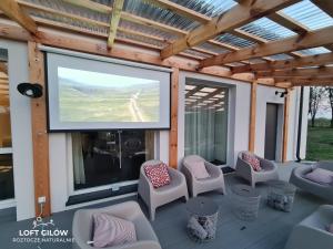 a screened in porch with a large screen television at LOFT GILÓW Siedlisko Roztocze in Gilów