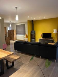 a living room with a black couch and a stove at Grote vakantiewoning nabij Brugge! in Damme