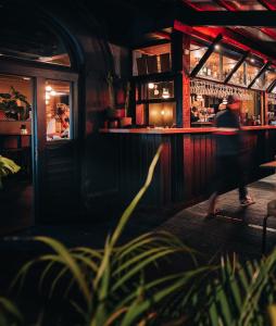 une personne marchant devant un bar dans l'établissement Deus Lodge of Heavy Leisure, à Bournemouth