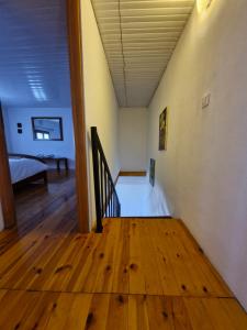 a hallway with a wooden floor and a stair case at Margarita's House in Tsagarada