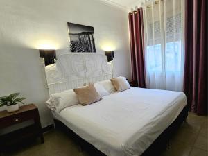 a bedroom with a white bed with two pillows at Hotel Wellamar in Sant Feliu de Guíxols