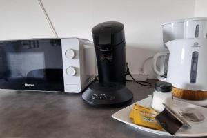 a black blender next to a microwave on a counter at Appartement Cosy le Bonduelle 2 in Anzin