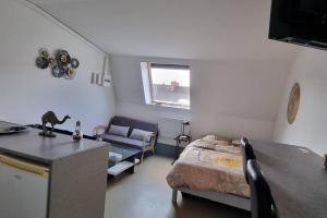 a room with a bed and a kitchen with a table at Appartement Cosy le Bonduelle 2 in Anzin