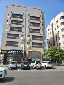 a parking lot with cars parked in front of a building at Palette Top Stars Hotel in Abu Dhabi