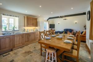 a kitchen and dining room with a wooden table and chairs at Plas Drygarn Ty Coch Crymych in Crymmych Arms