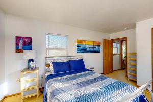 a bedroom with a bed with a blue comforter at Mermaid Beach House in Bandon