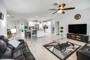 a living room with a couch and a flat screen tv at Lovely Lehigh Acres Home with Lanai, Pool and Spa! in Lehigh Acres