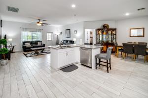 a living room with a kitchen and a dining room at Lovely Lehigh Acres Home with Lanai, Pool and Spa! in Lehigh Acres