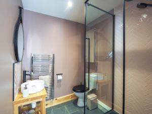 a bathroom with a toilet and a glass shower at Dryslwyn Rhydlewis in Troedyraur