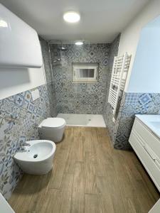 a bathroom with a toilet and a sink and a tub at Ginepro in Tirrenia