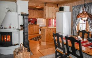 a kitchen with a fireplace and a table and a stove at 3 Bedroom Beautiful Home In Gjesåsen in Glorvika