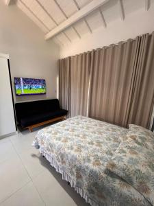 a bedroom with a bed and a flat screen tv at Praia do Forte / Studio in Mata de Sao Joao