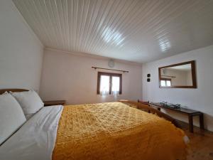 ein Schlafzimmer mit einem großen Bett und einem Spiegel in der Unterkunft Margarita's House in Tsagkarada