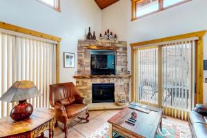 Una sala de estar con chimenea y una silla. en Coyote Run 9, en Moab