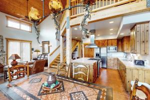 a large kitchen with wooden cabinets and a dining table at Coyote Run 9 in Moab