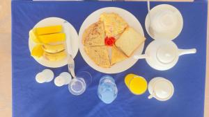 Blue Tides Hotel في نونغوي: طاولة زرقاء مع أطباق من الطعام والمشروبات