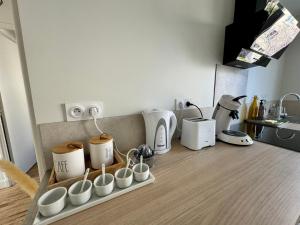 - un comptoir de cuisine avec des tasses et des appareils dans l'établissement Le 122 - Parking, à Rodez