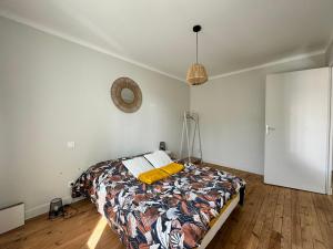 1 dormitorio con 1 cama en una habitación con paredes blancas en Le 122 - Parking, en Rodez