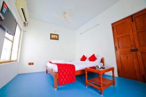 a bedroom with a bed and a table and a door at Sai White Villa Pondicherry in Puducherry