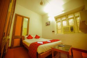 a bedroom with a bed and a table and a window at Sai White Villa Pondicherry in Puducherry
